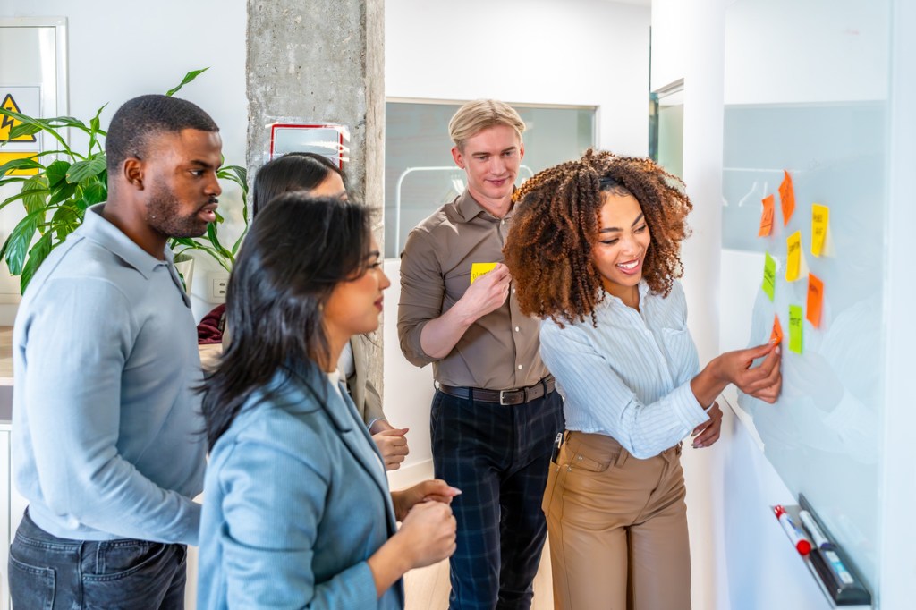 a group of business professionals using sticky notes for an icebreaker