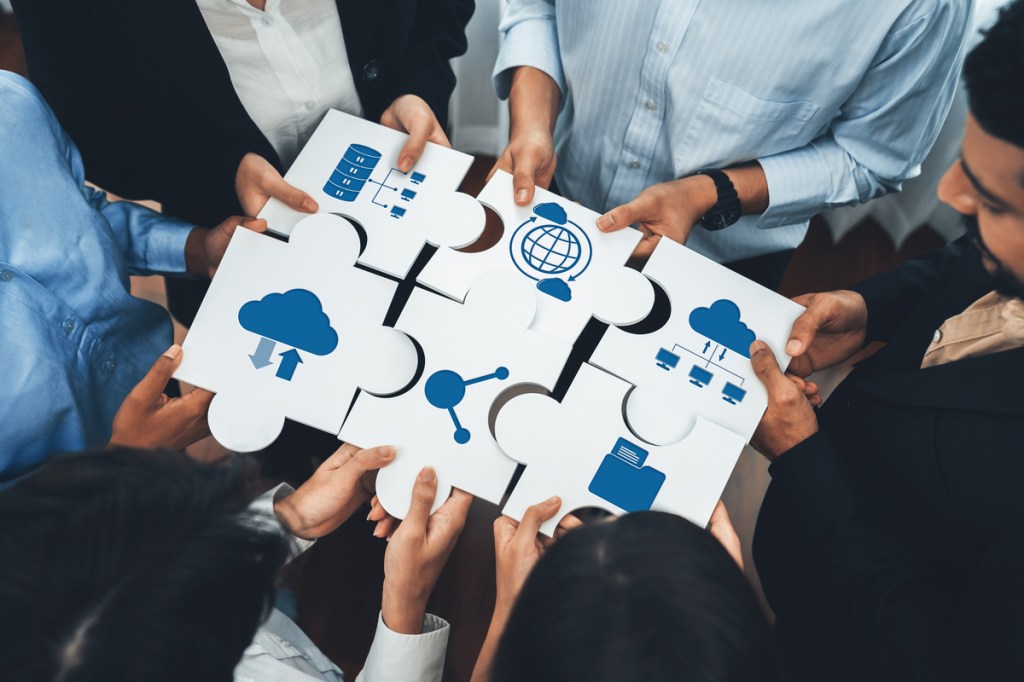 a group of professionals holding a puzzle together - collaborative team building activities