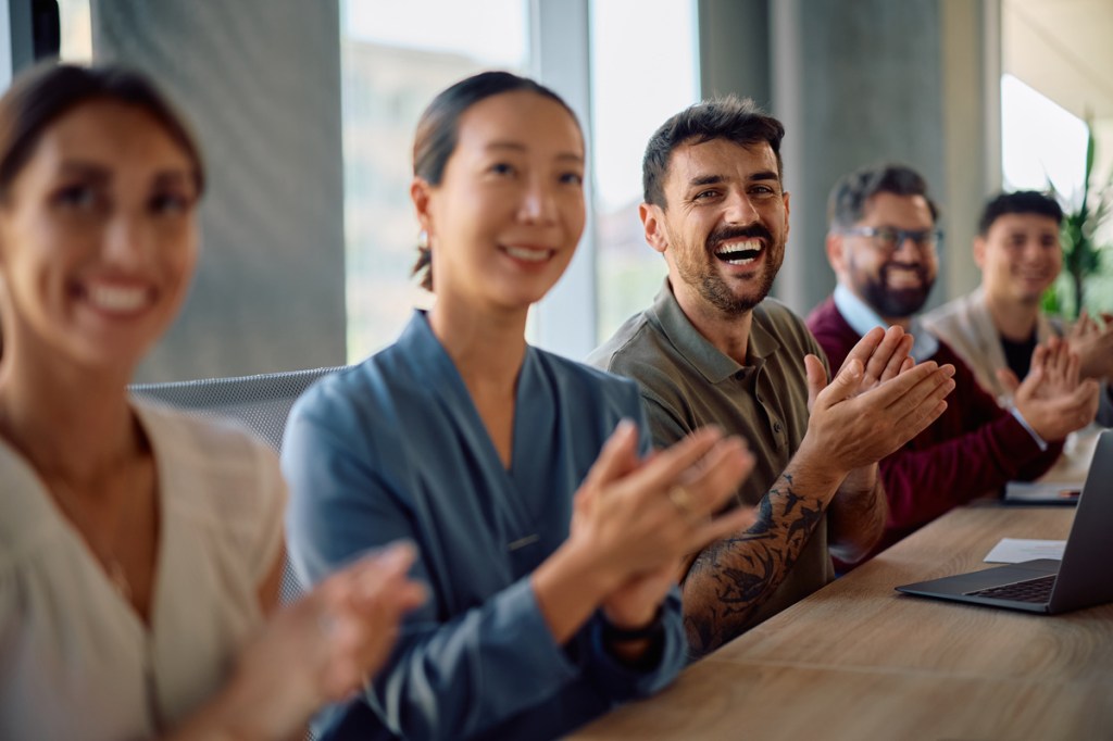 happy attendees applauding at a meeting