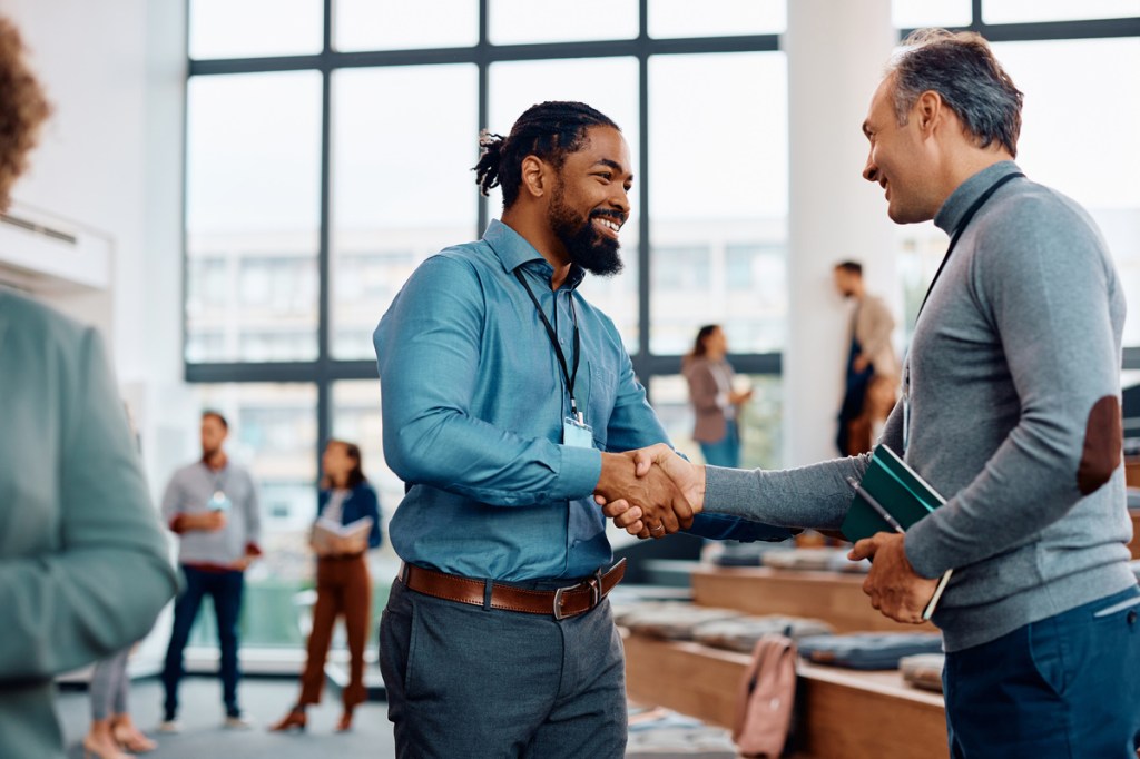 happy businessmen shaking hands at a business conference